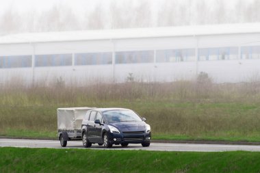 Güneşli kırsal yolda karavanı olan araba.