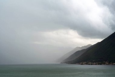 Sisli dağ manzarası ve aşağıdaki deniz koyuyla