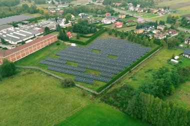 Sonbahar ormanlarıyla çevrili güneş panelleri olan bir ev.
