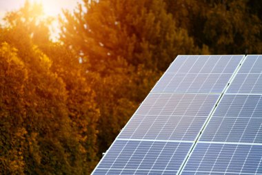 Arka planda parlayan güneş enerjisi kullanan modern bir ev.