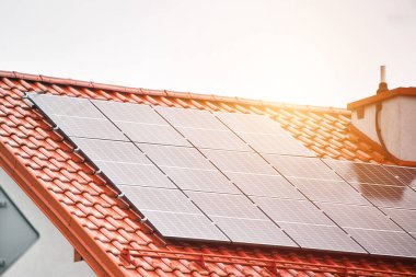 Güneş panelleri ve mavi gökyüzü olan ev çatısı