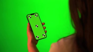 İçerideki yeşil ekran akıllı telefona bakılıyor