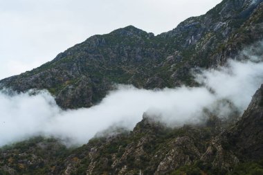 Fiyorttaki kayalık dağ sırtlarının ardında gizemli bir sis var.