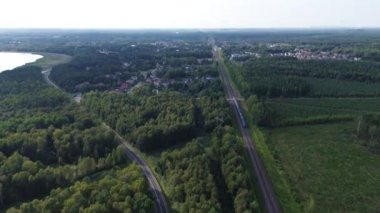 Demiryolu ve otoyolun havadan görünüşü gür orman manzarasını kesiyor.