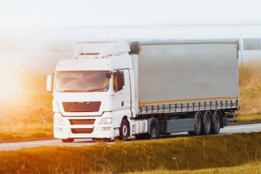 Endüstriyel bölgede beyaz kamyon sürüyor.