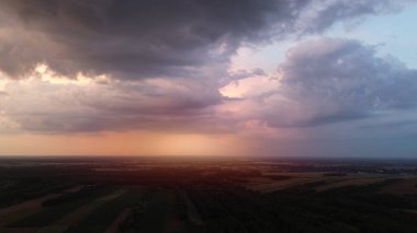 Gün batımında kırsal alanda fırtına bulutları ile turuncu gökyüzü