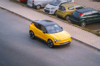 Modern sarı SUV su kenarında sürüyor.