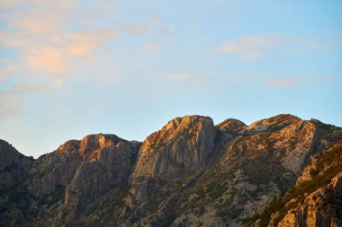 Parlak mavi gökyüzünün altında etkileyici dağ zirveleri