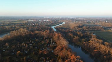 Şehir merkezinde nehir, park ve yüksek binalar var.