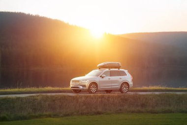 Güneşli orman yolunda çatı kutusu aracı.