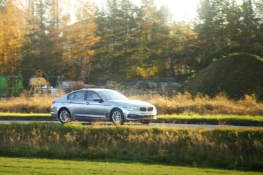 Araba çimenli tepelerden geçiyor.