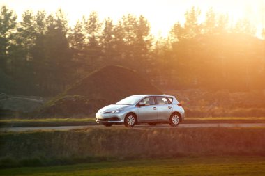 Hatchback kırsal kaldırım yolunda seyahat ediyor.