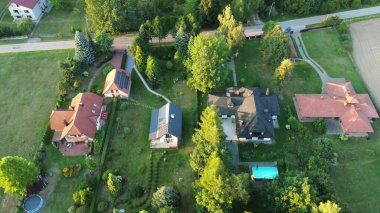 Lüks bir evin insansız hava aracı görüntüsü, bahçeli, yemyeşil bir ormana kurulmuş, doğa ve mimariyi harmanlayan..