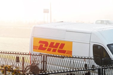 DHL teslimat minibüsü Polonya, Avrupa 17.01.2025 şehir sokağına park edilmiş.