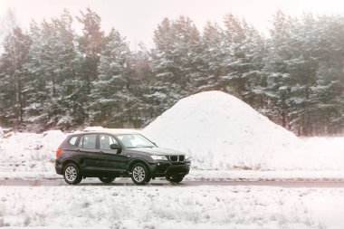 Güneşli bir kır yolunda giden SUV.