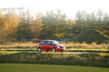 Çevre dostu araba, kır yolunda ilerliyor.