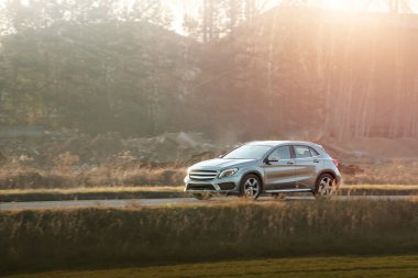 Boş bir sokakta modern küçük bir araba sürüyor.