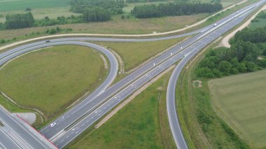 Çevresi tarım arazileriyle çevrili otoyol kavşağının havadan çekilmiş fotoğrafı.