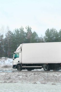 Kargo aracı donmuş otoyolda ilerliyor.