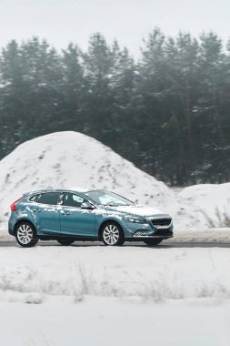 Kış yolunda giden küçük bir araba.