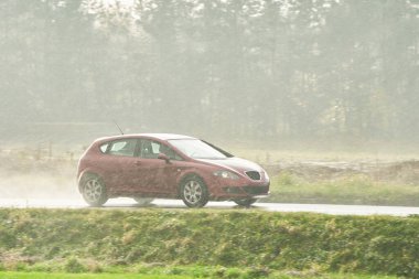 Yağmurlu yolda hız yapan şehir arabası.