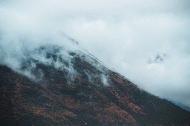 Sahildeki dramatik sisli dağ manzarası