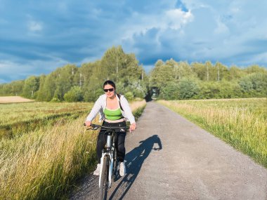 Yeşil alanlarda açık hava macerasında bayan bisikletçi