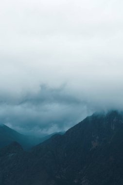 Bulutlu bir günde, sis dağların üzerinde yuvarlanıyor.