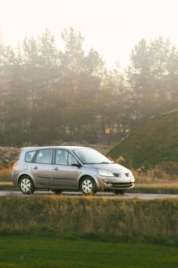 Açık kırsal yolda araba hareket halinde.