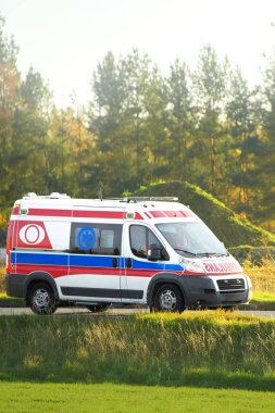 Kırsal alanda kırmızı ve beyaz ambulans