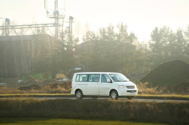 Beyaz otobüs güneşli otoyolda gidiyor.