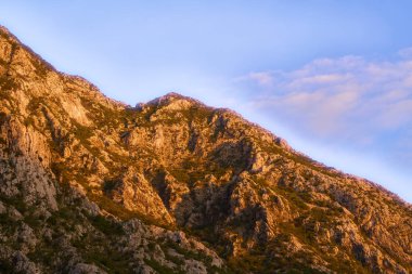 Gün batımında sakin su ve dağ arkası