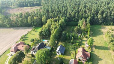 Drone 'un çektiği görüntüler ormanla çevrili bahçeli lüks bir evi gösteriyor. Doğa ve mimari arasındaki zıtlığı gösteriyor.