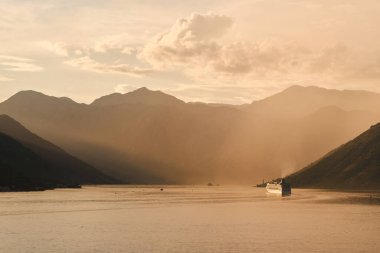 Gün batımında sakin sularda seyreden bir gemi.