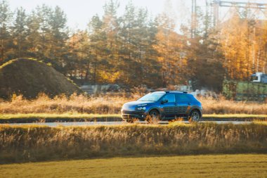 Beyaz SUV elektrikli araba dışarı çıkıyor.