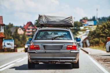 Klasik steyşın vagon. Çatıdaki çadır ağaçların yanından geçiyor.