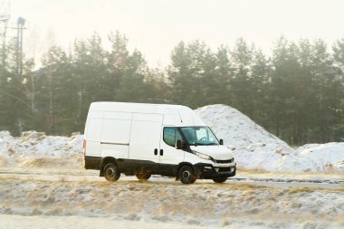 Minibüs karlı orman yolunda ilerliyor.