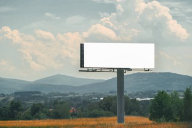 Otoyoldaki boş reklam panosu doğayla çevrili.