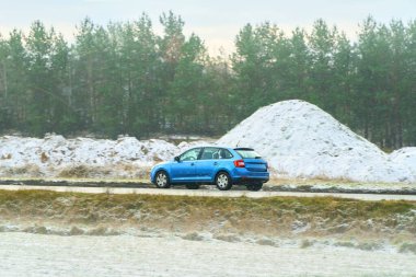 Kış manzarasında buzlu yolda küçük bir araba
