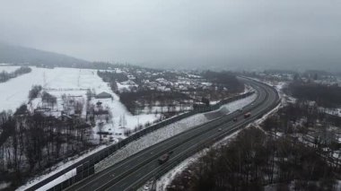 Karla kaplı şehir ve yol havadan görünüyor.