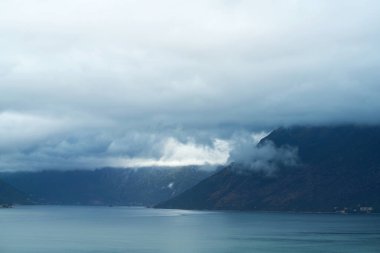 Dağları ve bulutlu gökyüzü ile sakin göl