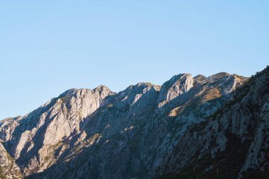 Alçak bulutlar dingin fiyortta kayalık tepelerin üzerinde yükselir.