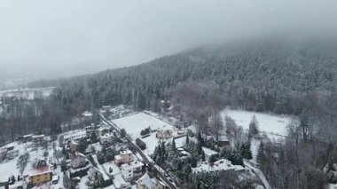 Karlı dağ yamaçları ve kışın kırsal köy