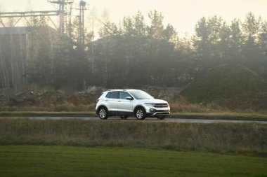 Kırsal yolda orman manzaralı bir araba.