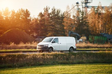 Sonbahar ağaçlarının yanında beyaz nakliye aracı