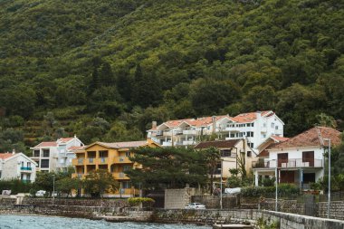 Dağlar ve su kıyısında bir köy.
