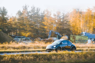 Sessiz kırsal bir yolda modern bir araba.