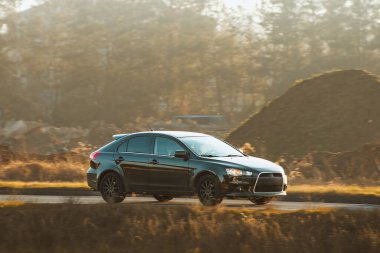 Kırsal yolda küçük bir hatchback sürücüsü