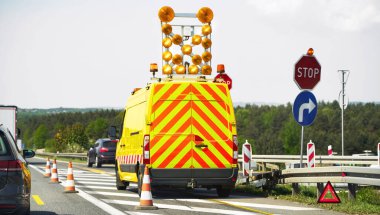 Yol yapımı sırasında trafik kontrol minibüsü ve arabalar