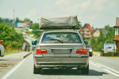 Çatıda çadırı olan klasik bir araba.